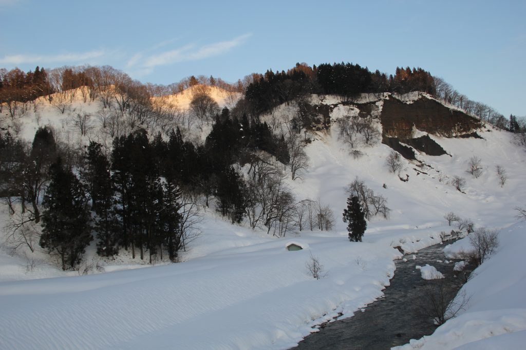 岩野道郎さん　作品名『夕日でほんのりと赤く染まった秋葉山頂と保倉川』